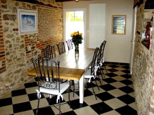 Un comedor con mesa y sillas de madera. en Chambres d'Hôtes Les laitières, en Beaurepaire