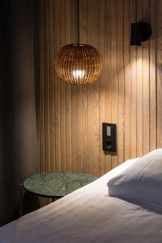a bedroom with a bed and a table and a lamp at Lapland Hotels Ylläskaltio in Äkäslompolo