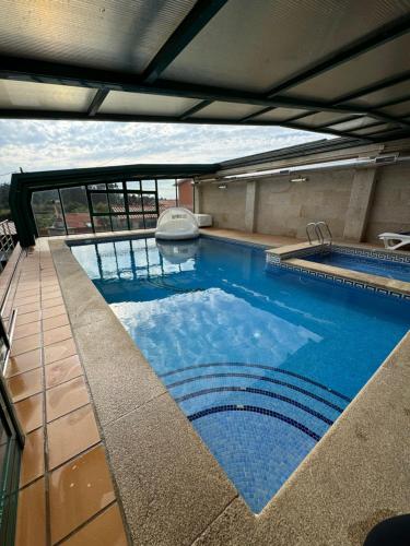 a large swimming pool on top of a building at Apartamento Cubo de Cristal con piscina y vistas al mar in O Grove