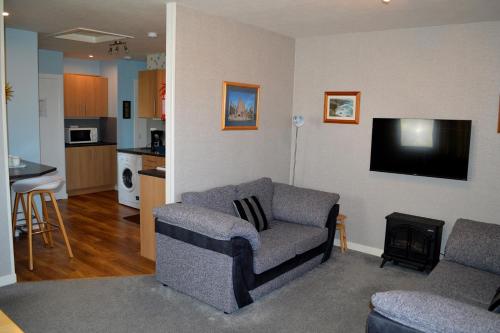 a living room with a couch and a flat screen tv at Bachylis Self Catering in Kirkwall