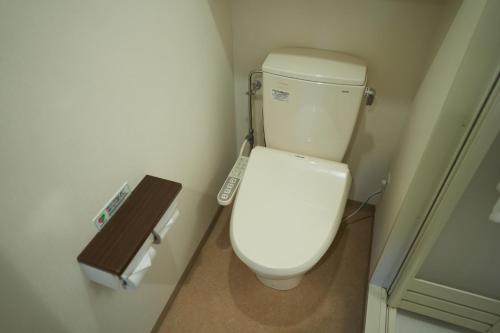 a white toilet in a bathroom with a sink at Dormy Inn Higashi Muroran in Muroran