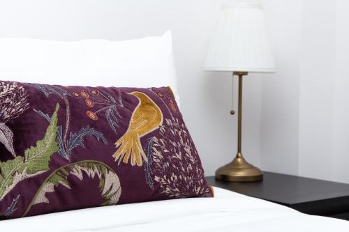a pillow sitting on a bed next to a lamp at SAV - 4 Bed Town House, Harrow in Harrow