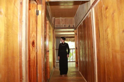 a woman walking down a hallway in a building at Ba Be Retreat in Bak Kan