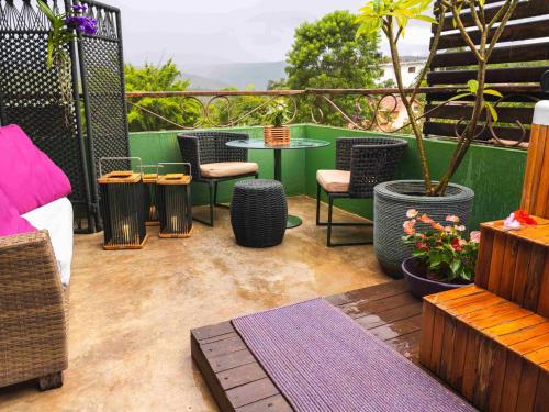 a patio with chairs and a table and a potted plant at Casa da Lua Pousada in Alto Paraíso de Goiás