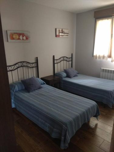 a bedroom with two beds and a window at Apartamentos Miravalles B in Villaviciosa