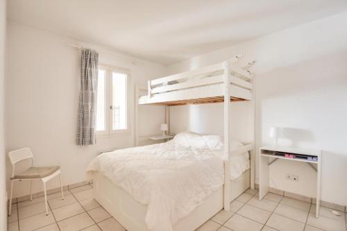 - une chambre blanche avec des lits superposés et un bureau dans l'établissement Village Pont Royal en Provence - maeva Home - Appartement climatisé 3 pièces 6 personnes - Prestige MAE-9681, à Mallemort