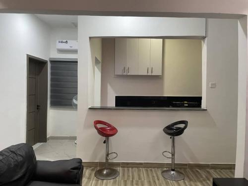 a living room with two red chairs and a counter at Plot9 Road9 NTA road in Port Harcourt