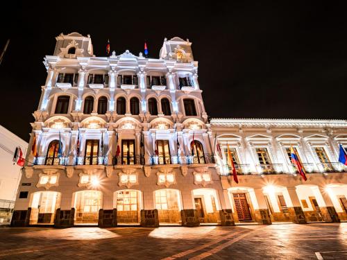 a large white building at night with lights at Plaza Grande Hotel in Quito