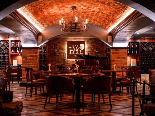 a restaurant with tables and chairs and a brick wall at Plaza Grande Hotel in Quito