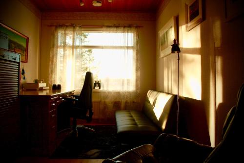 a living room with a couch and a window at Keltainen talo - tilava huvila lähellä Saloa in Vartsala