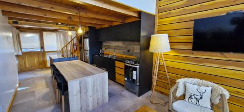 eine Küche mit einer Holzwand mit einem TV und einem Stuhl in der Unterkunft Complejo Base 41 in San Carlos de Bariloche