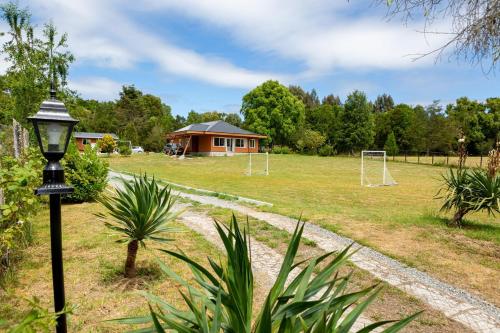 a park with a house and a soccer field at Hermosa casa de campo cerca de Puerto Varas y el aeropuerto in Puerto Montt