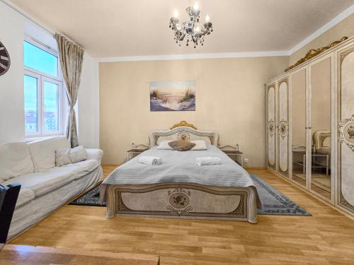 1 dormitorio con cama, sofá y lámpara de araña en Davidov Stays Danube, en Viena