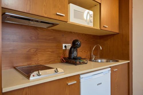 a kitchen counter with a sink and a microwave at Con Parking y Escritorio I Apartamento en Incles I AndBnB in Canillo