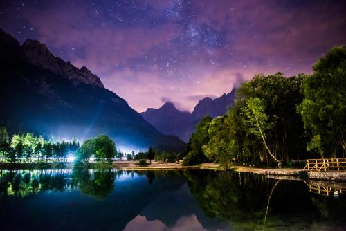 a starry night over a lake in the mountains at Riversound in Kranjska Gora