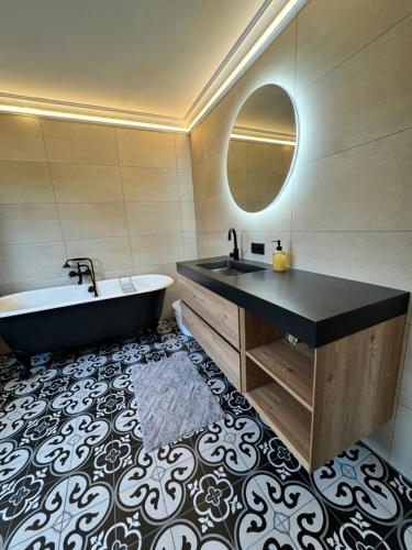a bathroom with a tub and a sink and a mirror at Polderzicht in Ossendrecht