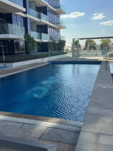 a large swimming pool in front of a building at Dubai damac hills luxurious appartment in Dubai