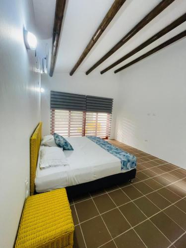 a bedroom with a bed and a yellow bench at Hotel Chiniu in Palomino