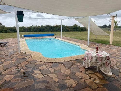 a swimming pool with a table and a tent at CHACRA Los Ombues in Colonia Valdense