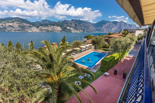 a view of the water from a balcony with a swimming pool at Hotel Capri in Malcesine