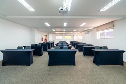 an empty room with chairs and tables in it at Hotel Plaza Mayor in Santo André