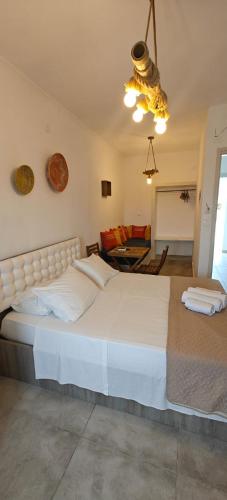 a bedroom with a large white bed and a living room at Joannes Vacation Rooms in Adamas