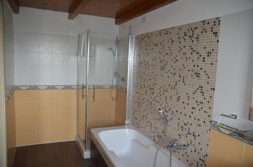 a bathroom with a tub and a glass shower at Le Ali del Falco in Cuceglio