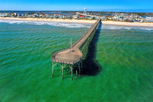 a pier in the water next to a beach at 104 Queen Pet Friendly Suite, 1st Floor Nest in Surf City