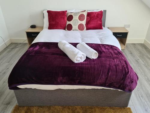 a bedroom with a large bed with purple sheets and pillows at SAV Nottingham Road 1 & 2 Bed Flats Loughborough in Loughborough