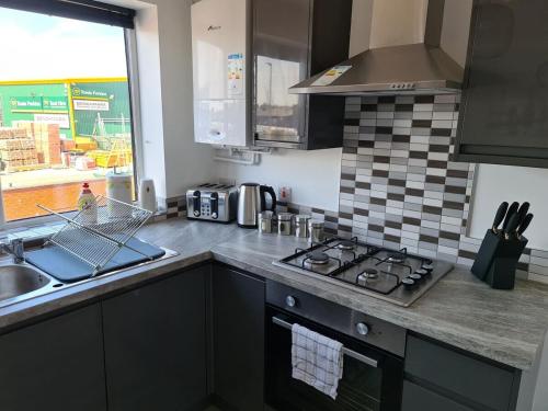 a kitchen with a stove top oven next to a sink at SAV Nottingham Road 1 & 2 Bed Flats Loughborough in Loughborough