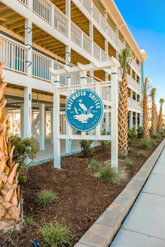 a hotel with a sign in front of a building at 104 Queen Pet Friendly Suite, 1st Floor Nest in Surf City