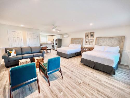 a hotel room with two beds and a couch and a living room at 104 Queen Pet Friendly Suite, 1st Floor Nest in Surf City