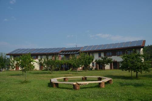 a building with a bench in the middle of a field at Le Ali del Falco in Cuceglio