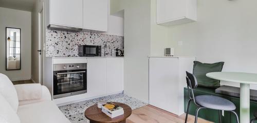 un salon avec une table et une cuisine dans l'établissement Appartement d'une chambre, à Paris