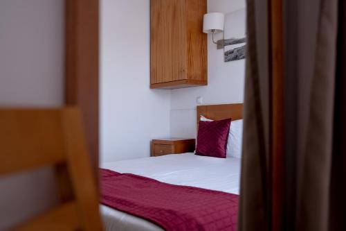 a bedroom with a bed with a purple pillow at Aldeia das Adegas in São Roque do Pico