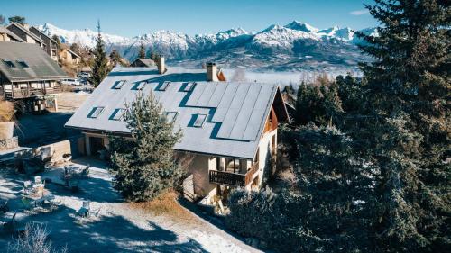 an aerial view of a house with snow covered mountains at Maison L'Aiguille - 2 appartements, 5 chambres et table d'hôtes au pied de la montagne à la station de Laye in Laye