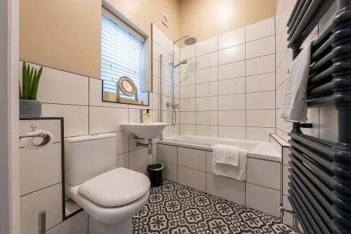 un bagno con un water, un lavandino e una vasca di Spacious & relaxing cottage stay with free parking a Cark
