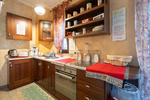 una cucina con armadi in legno e piano di lavoro rosso di sole a Roma