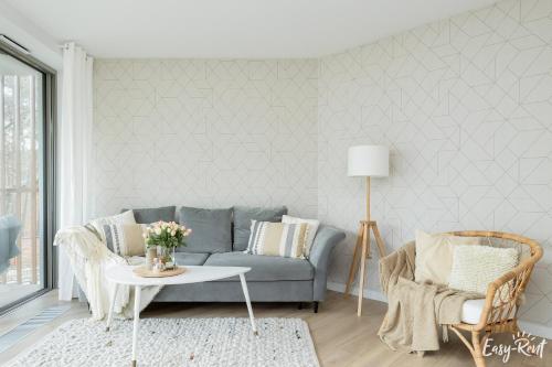 a living room with a couch and a table at Pinea 110 - basen, sauna, jacuzzi w cenie pobytu - bezpośredni widok na morze - Easy - Rent Apartments in Pobierowo