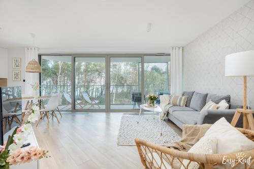 a living room with a couch and a table at Pinea 110 - basen, sauna, jacuzzi w cenie pobytu - bezpośredni widok na morze - Easy - Rent Apartments in Pobierowo