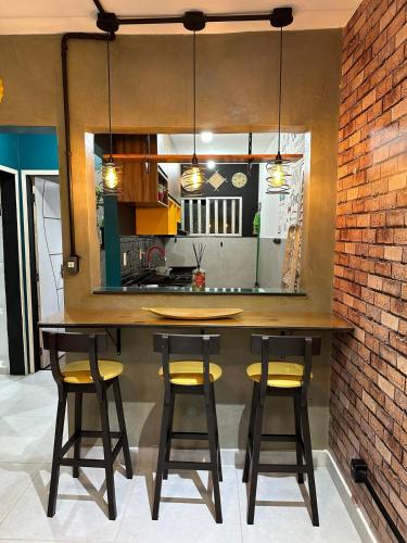 a kitchen with a bar with yellow bar stools at Ap design 002 Cond Cais da Sagração Angelim in São Luís