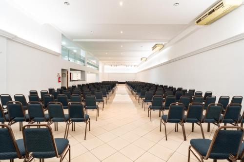 an empty room with rows of chairs in a classroom at Hotel Plaza Mayor in Santo André