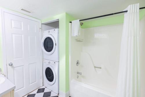 a bathroom with a washer and dryer next to a shower at The Trinidad -Pool & Parking in Key West
