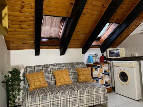 a living room with a couch and a washing machine at Hosting Dreams Attics - Duomo in Milan
