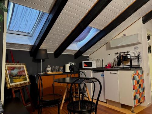 a kitchen with a table and some chairs in a room at Hosting Dreams Attics - Duomo in Milan