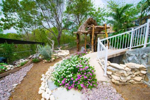 a garden with flowers and a bridge and a house at GARNET--A gem at DEE'S PEARL in Carriacou