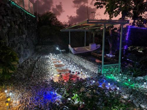 a garden with candles and lights on the ground at GARNET--A gem at DEE'S PEARL in Carriacou