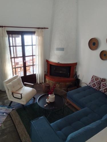 a living room with a blue couch and a fireplace at Mountain and Sea view in Miléai
