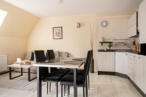 kuchnia i jadalnia ze stołem i krzesłami w obiekcie Apartamenty Tetmajera APARTZAKOP w Zakopanem