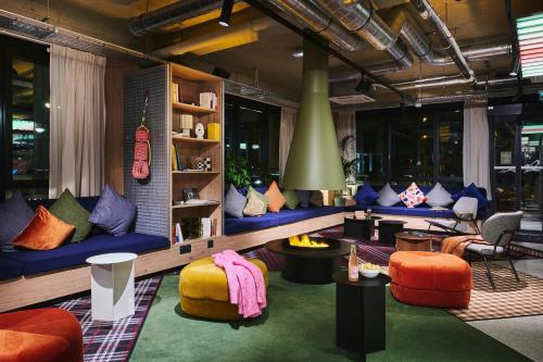 a living room with colorful couches and chairs at Moxy Annecy in Annecy
